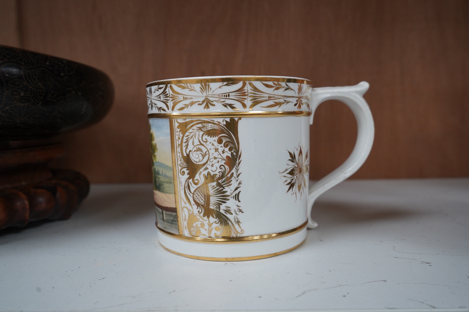 A Bloor Derby ‘Porter’ mug, c.1800-10, painted with a country scene, in the manner of Daniel Lucas, 11cm high. Condition - crack to base internally